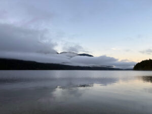 Still lake with mountains and clouds